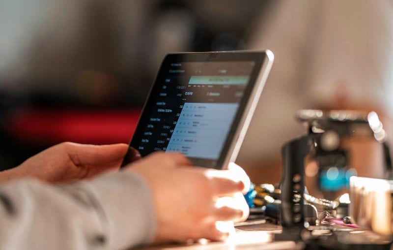 A close-up of a maintenance technician's hands holdign a tablet.